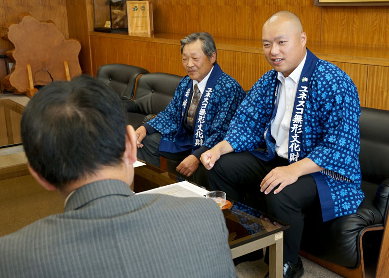 八重樫市長（左）に南米での成果を報告する斉藤さん（右）と八重樫さん