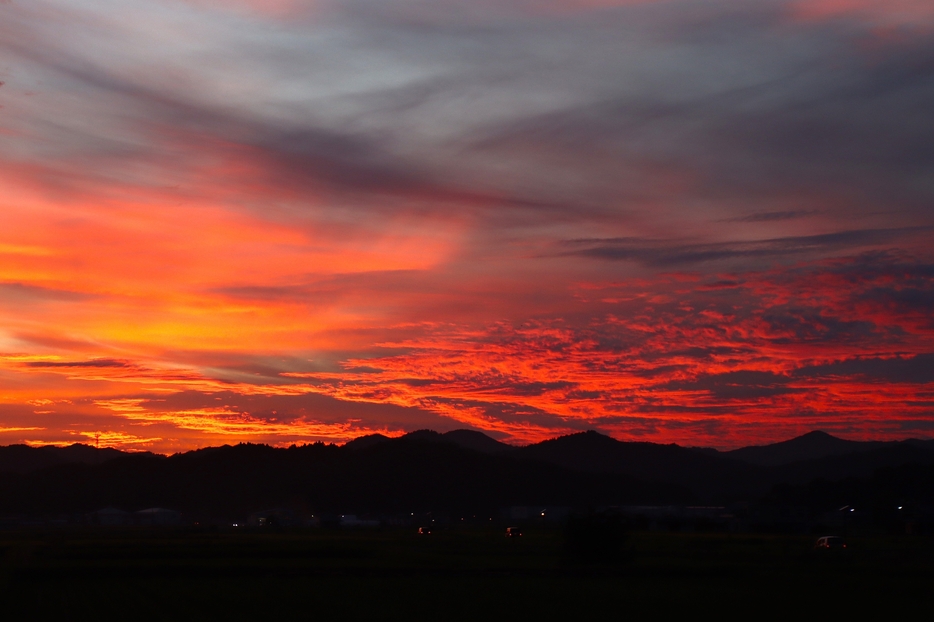 農村を真っ赤に染める夕日。厳しい残暑の中、秋めいた夕焼けに少し心がほっとする＝2024年9月19日午後6時10分、兵庫県丹波篠山市内で