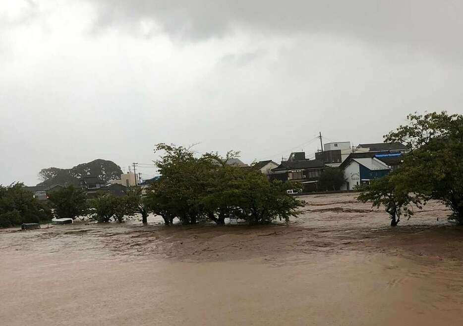 大雨であふれた濁流。車が水没している＝21日午前、石川県輪島市（住民提供）