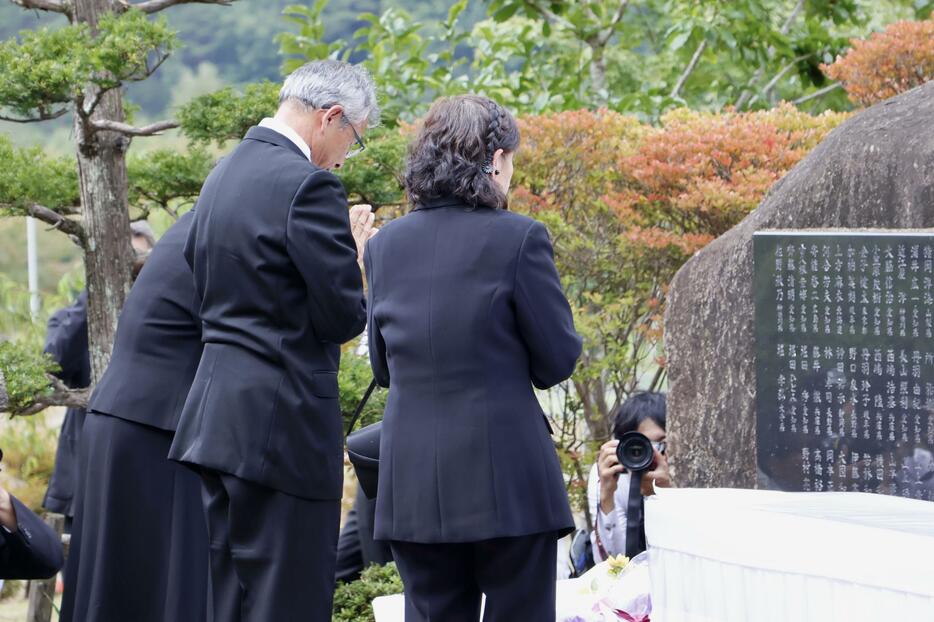 御嶽山の噴火から10年となり、慰霊碑を前に手を合わせる遺族ら＝27日午前、長野県王滝村