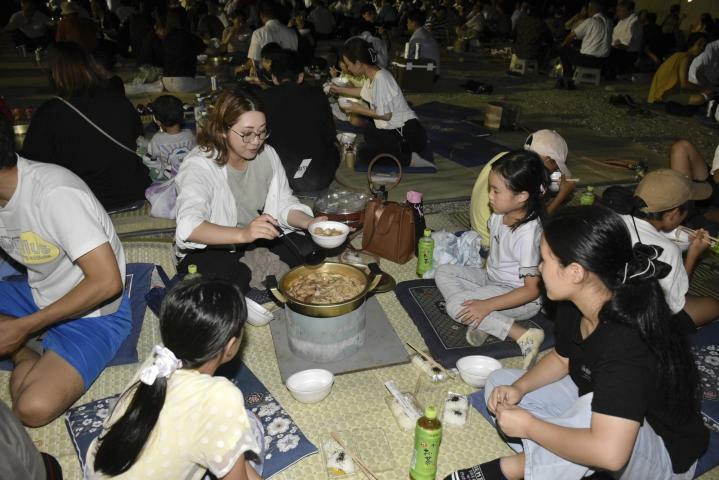 試食会で鍋を囲んでいもたきを楽しむ近隣住民ら