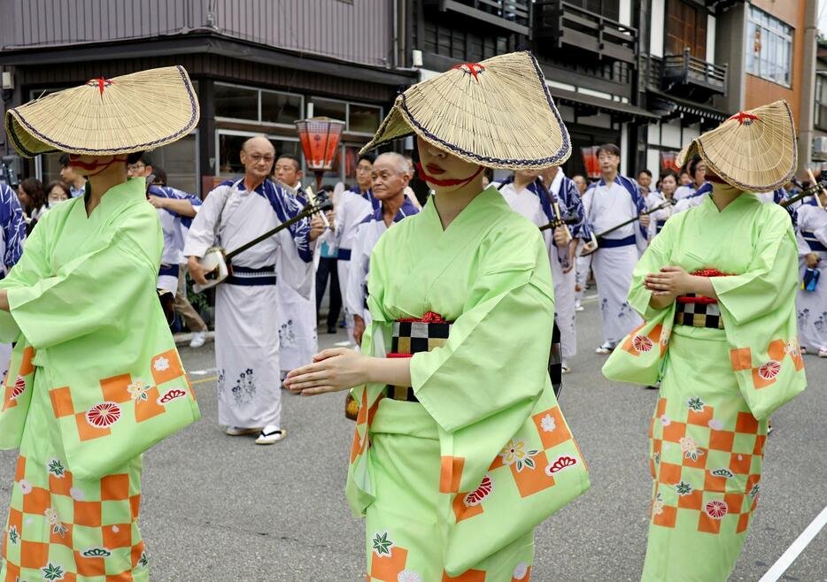 「おわら風の盆」が始まり、編み笠を目深にかぶって舞う浴衣姿の踊り手＝1日夕、富山市