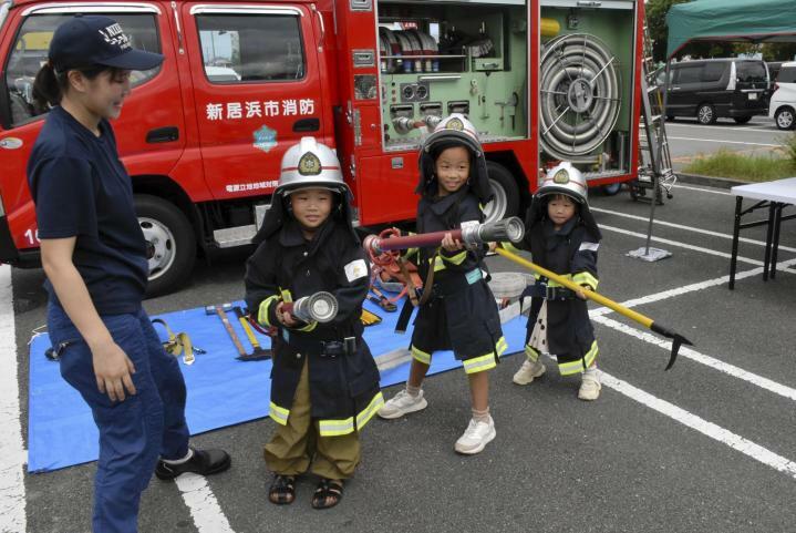 防火衣を着てポーズを取る子どもたち