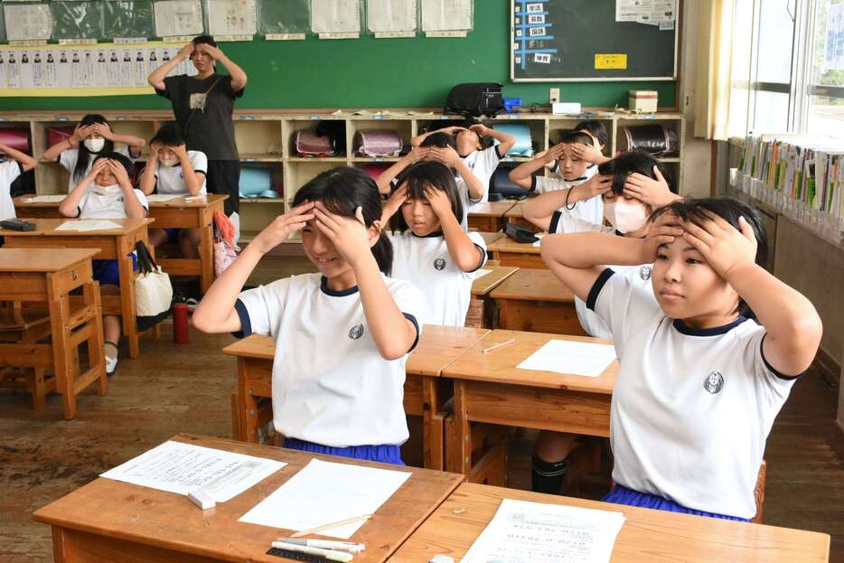 おでこに手を当て深呼吸する児童＝出水市の下水流小学校