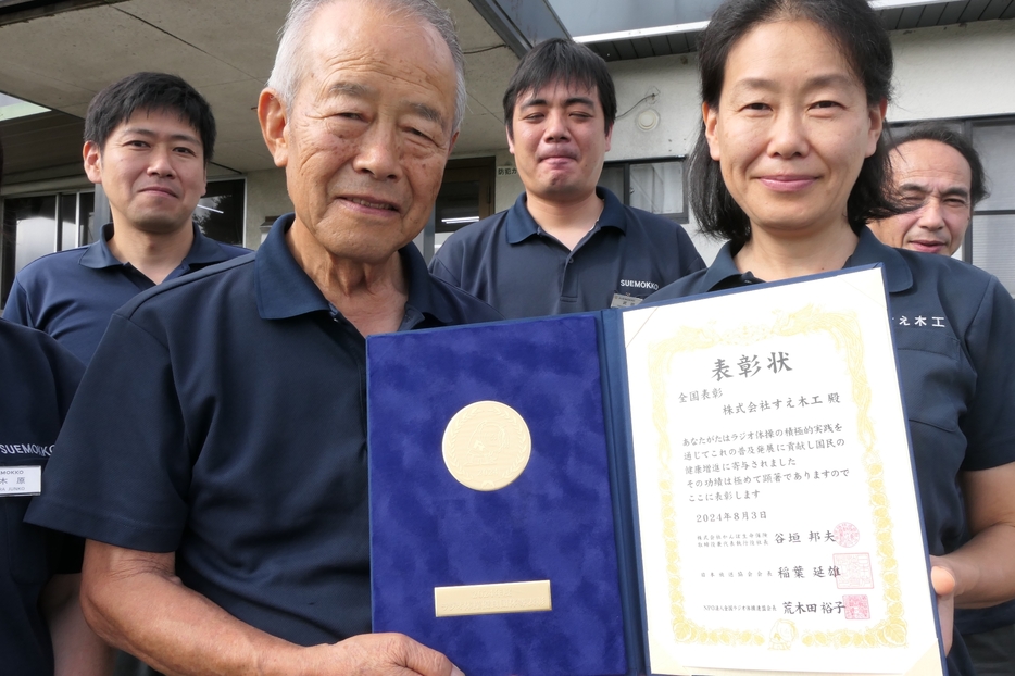 表彰状とメダルを手にする英典会長（左）と幸子さん=岡山県津山市で