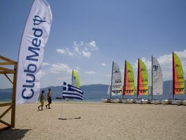 People walk by catamaran sail boats at Club Med in Grecolimano, Greece.