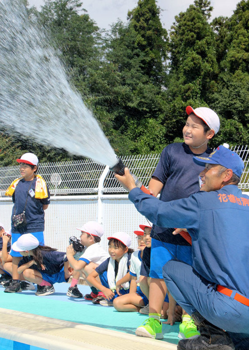 花巻市消防団4分団の出前授業で放水を体験する矢沢小の3年生