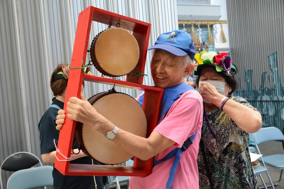 お手製のチンドン太鼓を抱えて演奏準備を進める川野さん