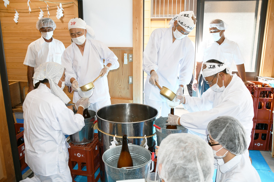 神酒を瓶に詰める氏子の人ら＝南房総