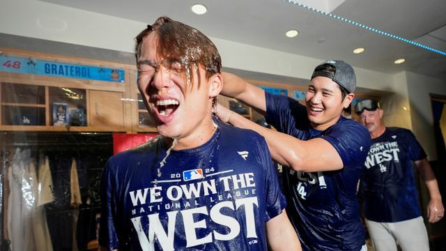 大谷翔平選手からシャンパンをかけられ笑顔を見せる山本由伸投手【写真：AP/アフロ】