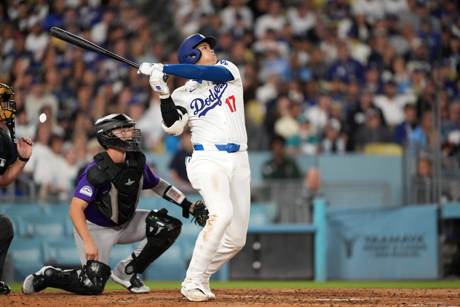 Sep 20, 2024; Los Angeles, California, USA; Los Angeles Dodgers designated hitter Shohei Ohtani (17) hits a two-run home run in the fifth inning as Colorado Rockies catcher Hunter Goodman (15) at Dodger Stadium. Mandatory Credit: Kirby Lee-Imagn Images