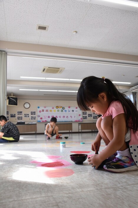 床に色を塗る子どもたち（平川地域交流センターで）