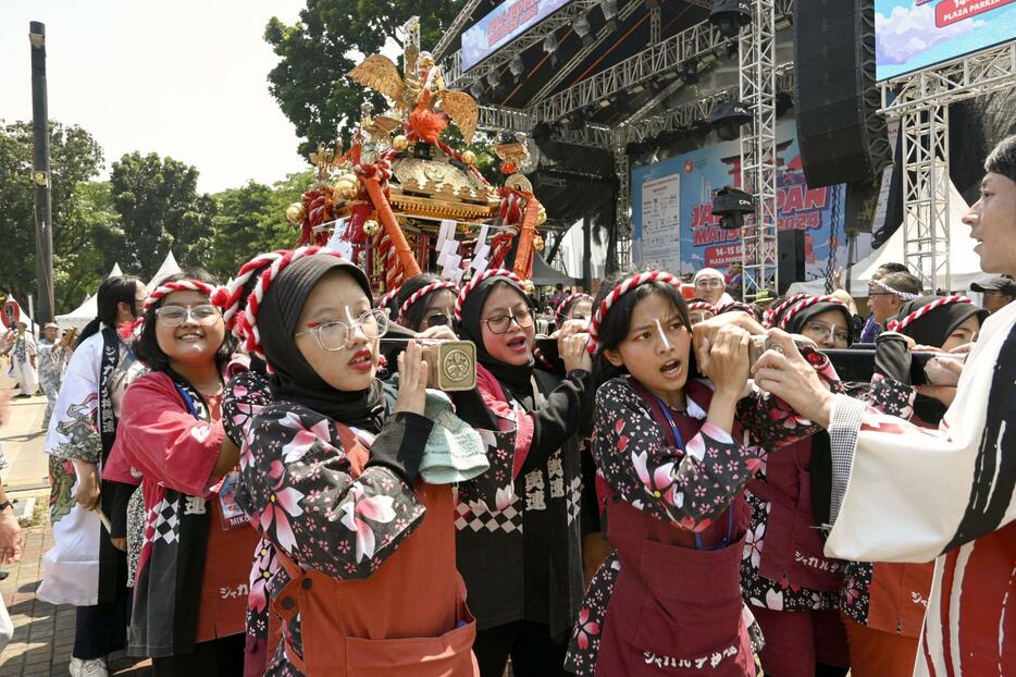 14日、日本祭りでみこしを担ぐ人たち＝ジャカルタ（共同）