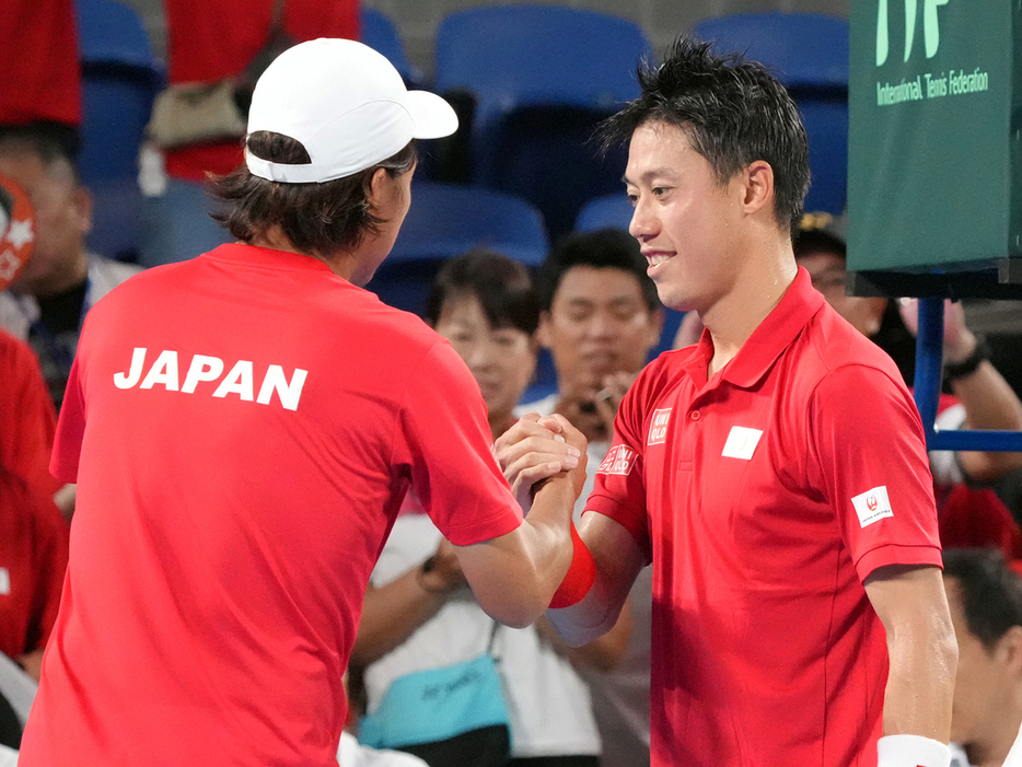 「デビスカップ」ワールドグループI「日本対コロンビア」（東京・有明コロシアム）で2勝目を挙げて添田豪監督（左）と握手を交わす錦織圭（ユニクロ）（Getty Images）