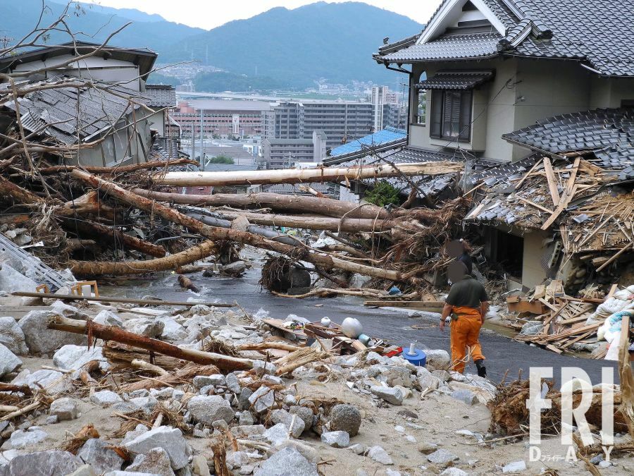 安佐南区緑井地区。田んぼがあったところ（手前）に土砂が堆積して景色が一変した。道路はまるで川のようだ（’14年９月12日号）