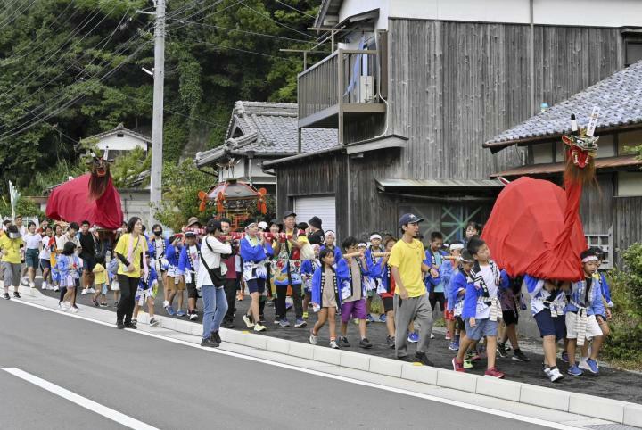 牛鬼やみこしを順に担ぎながら地区内を錬る参加者