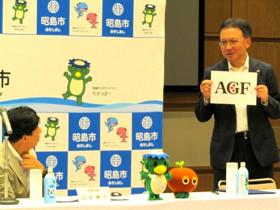 AGFのロゴマークの3つの赤い丸について臼井市長に説明する島本社長