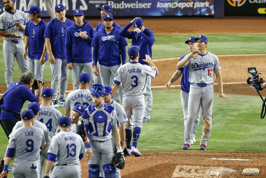 マーリンズに大勝しタッチを交わす大谷（右端）ら。ドジャースは12年連続となるプレーオフ進出を決めた＝マイアミ（共同）