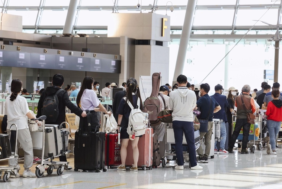 韓国・仁川国際空港で搭乗手続きのため列を作る乗客ら＝2022年（聯合＝共同）