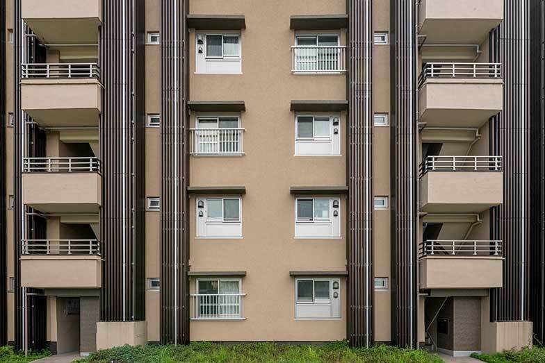 外から窓を見るとフルリノベーションをされた部屋かそうでない部屋かがわかるという。手摺がなく窓の下半分がパネル状になっているところがキッチンに変わったフルリノベーションの部屋（写真撮影／桑田瑞穂）