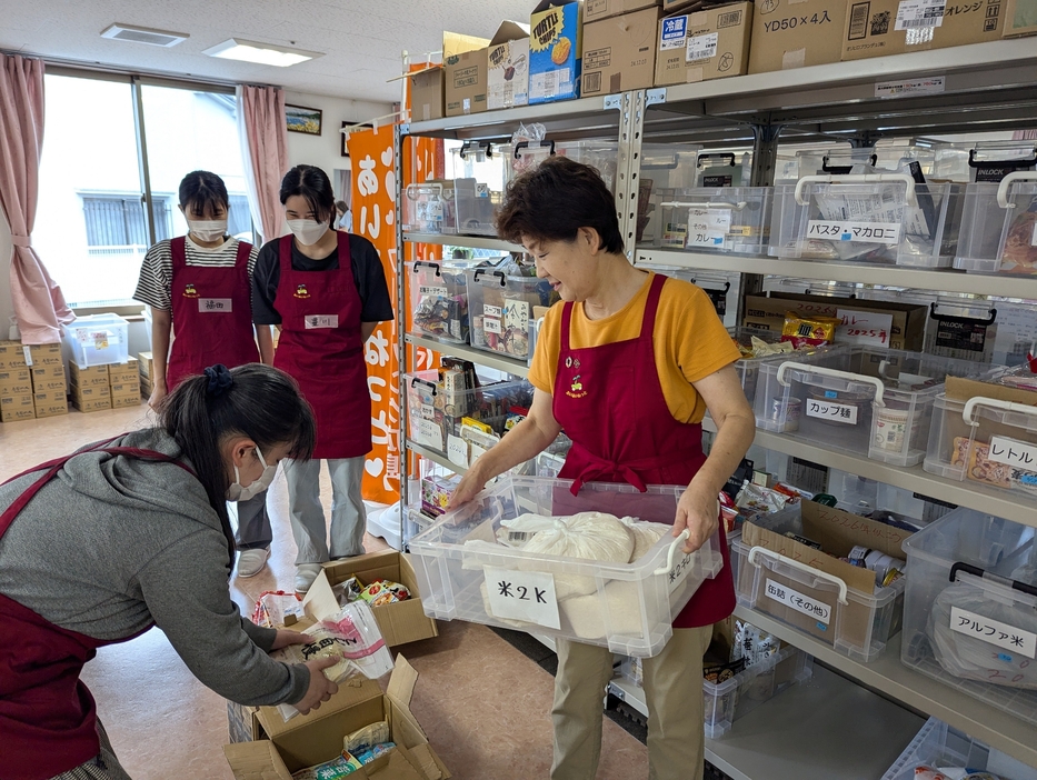 支援が必要な人に送る食料を仕分ける、あいあいねっとのスタッフ（広島市安佐北区）