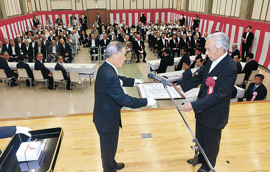 油野市長（左）から表彰状を受け取る功労者＝かほく市役所