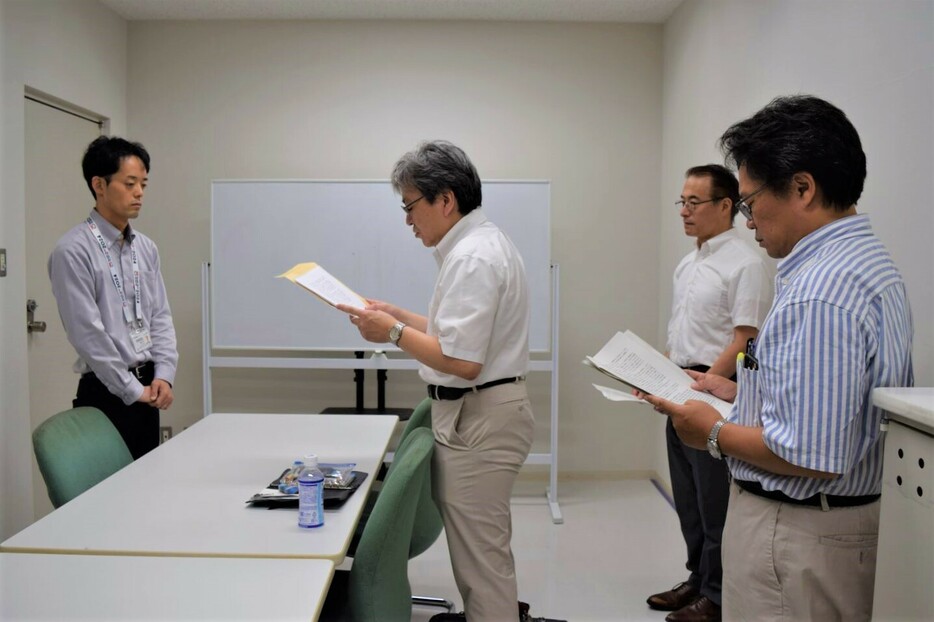 8月5日、東京都庁で都政策企画局の廣田淳担当課長（左）に向けて要請文を読み上げる外村大・東京大学教授（中央）。（撮影／吉永磨美）