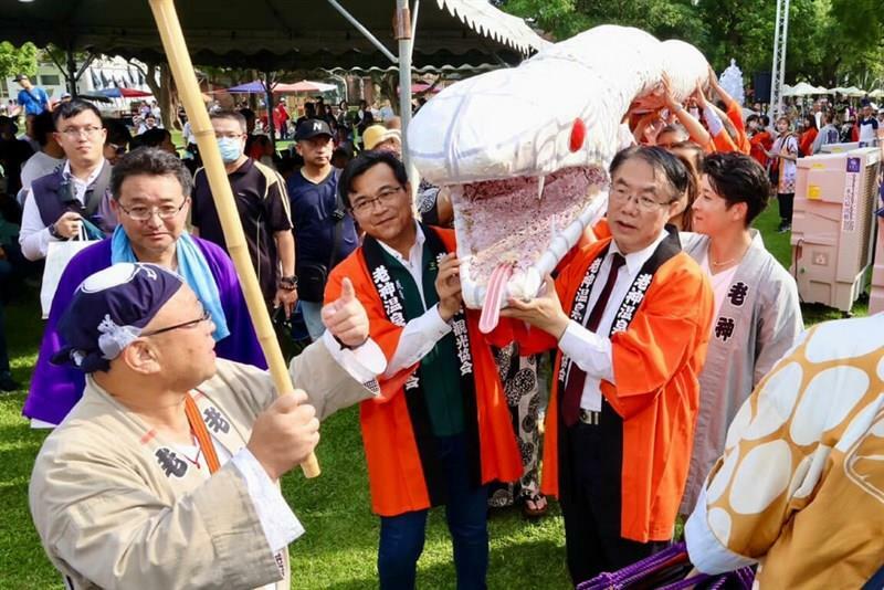 群馬県の伝統工芸品を紹介する特別展が27日、台南市の総爺芸文センターで始まった。29日には黄偉哲台南市長（手前右）が沼田市の老神温泉大蛇まつりで行われる大蛇みこしの練り歩きに参加した＝同市政府提供