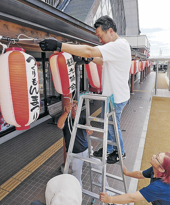 提灯を飾り付ける実行委メンバー＝あいの風とやま鉄道福岡駅