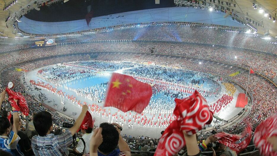 北京五輪開会式での、中国選手団の入場行進。国旗などを手に盛り上がる中国人の観客ら＝2008年8月8日、北京の国家体育場（時事）