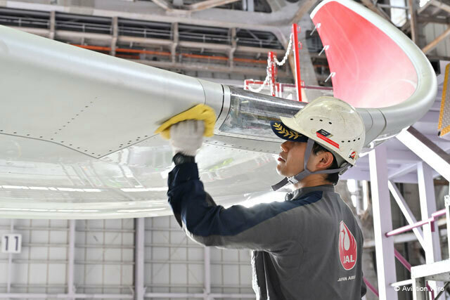 今治タオルの端材を再利用した整備用ウエスでA350-900に取り付けたナビゲーションライトのカバー周囲を清掃するJALの整備士＝24年9月24日 PHOTO: Tadayuki YOSHIKAWA/Aviation Wire