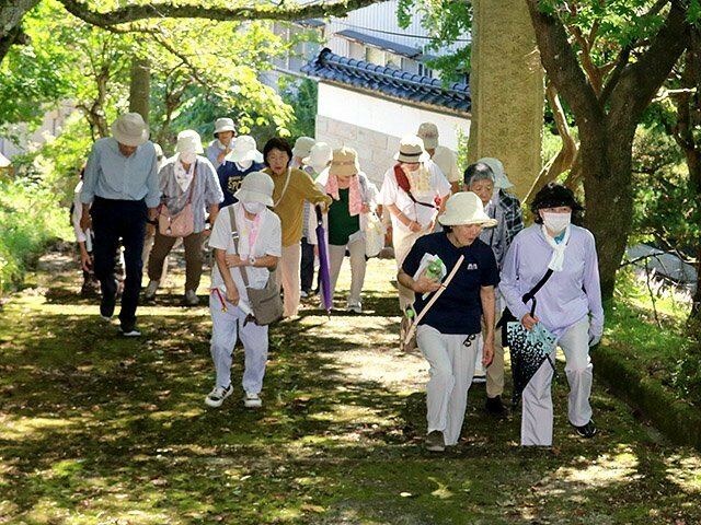 消防神社の階段を上る会員＝小矢部市城山町