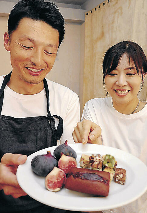 フィナンシェや原料の黒イチジクを見せる玉井さん（左）=小松市安宅町の菓子店