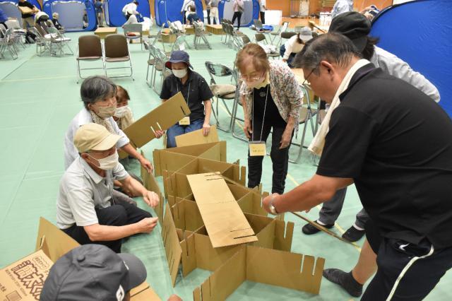 避難所運営訓練で段ボールベッドを組み立てる神宮西自治会の参加者＝２９日午前、宮崎市・南九州大