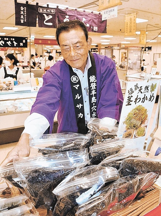 地震に続く豪雨被害から立ち上がろうと、物産展の売り場に立つ坂谷さん。能登地方の産品を買い求める来場者に感謝を伝えている