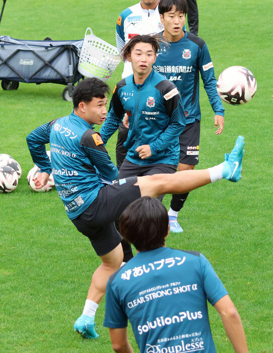 浮き球に右足を伸ばして止めにいくJ１札幌MFスパチョーク（左＝カメラ・砂田　秀人）