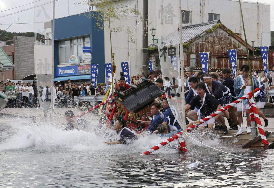 勝浦八幡神社の例大祭で参加者に担がれ海に入るみこし＝15日午後、和歌山県那智勝浦町