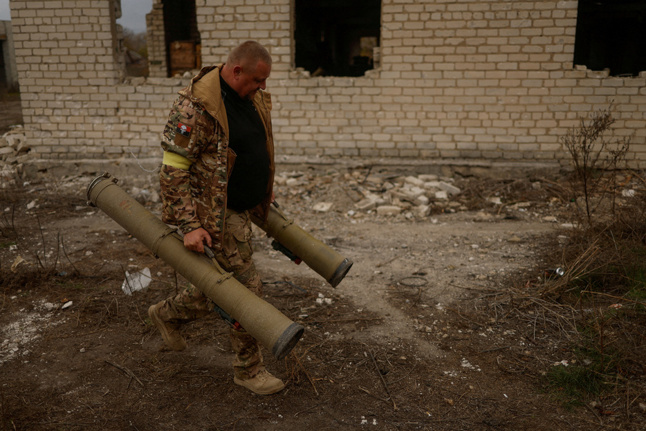 　９月２４日、ウクライナのブラシウク大統領顧問は、ウクライナの戦場で見つかったロシア軍の武器について、外国製部品の約６０％が中国を経由したものだったと述べた。写真はウクライナ・ヘルソンのロシア軍が去った場所から武器を運び出すウクライナの兵士。２０２２年撮影（２０２４年　ロイター/Valentyn Ogirenko）