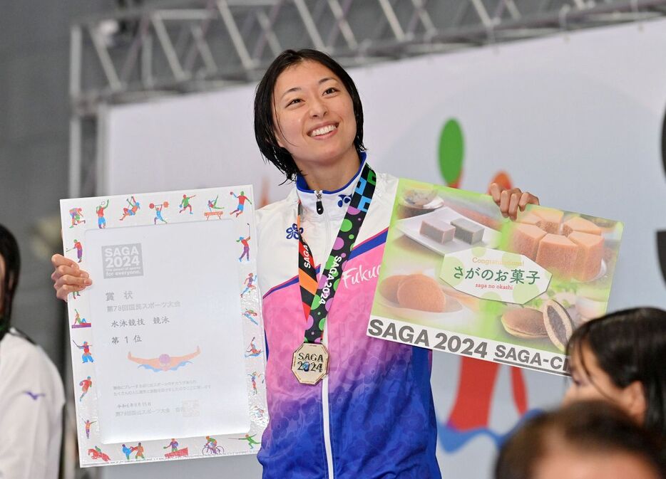 成年女子100メートル平泳ぎで優勝し、表彰式で笑顔の鈴木聡美（撮影・軸丸雅訓）