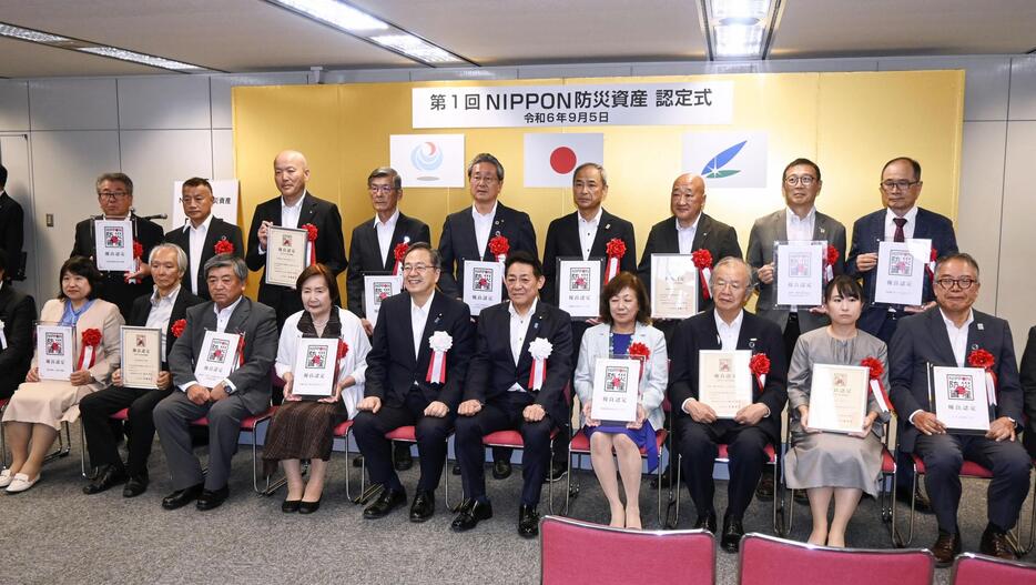 斉藤国交相（前列中央左）と松村防災相（同右）と記念写真に納まる「NIPPON防災資産」の優良認定の関係者ら＝5日午後、東京都千代田区