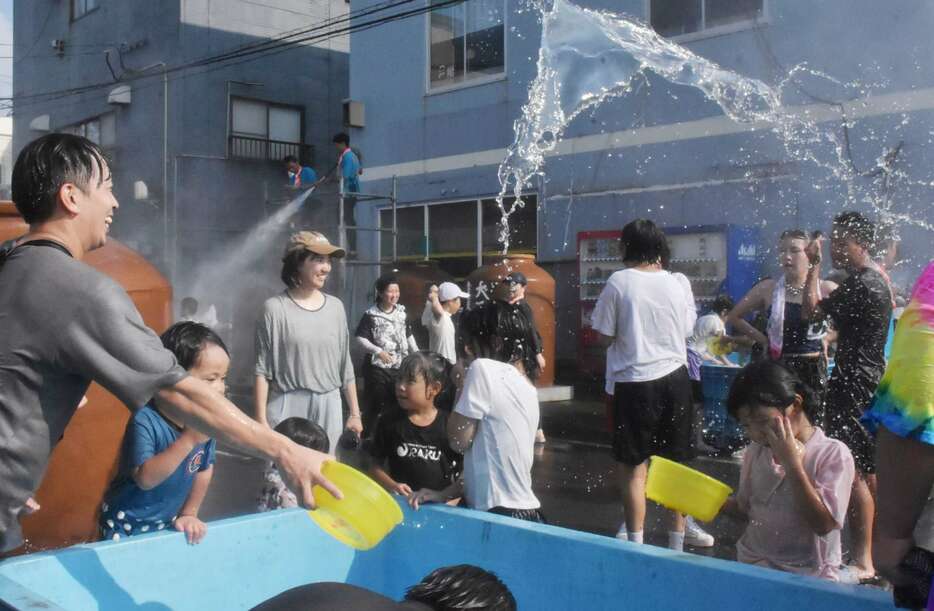 歩行者天国で温泉水を掛け合う来場者＝阿久根市大丸町