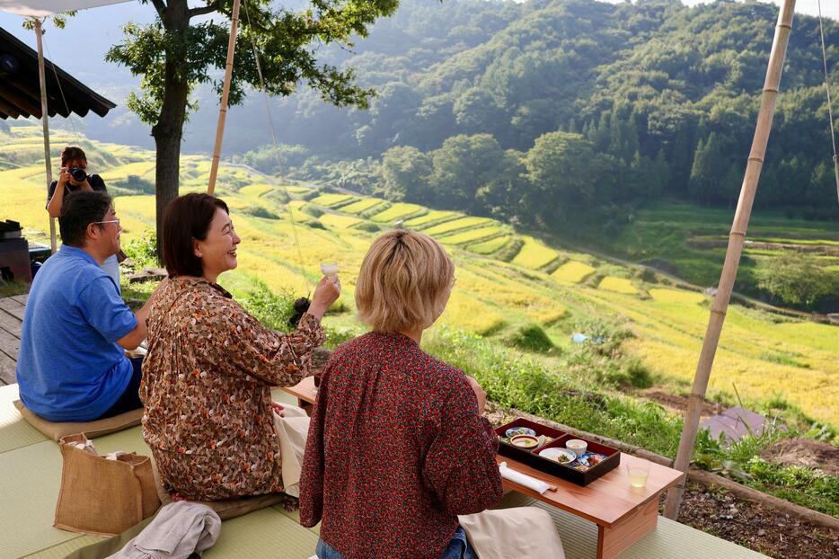 「稲倉の棚田」を眺めながら朝食を味わう参加者