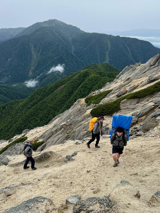 東駒ケ岳の標識を順番で担いで登った3人