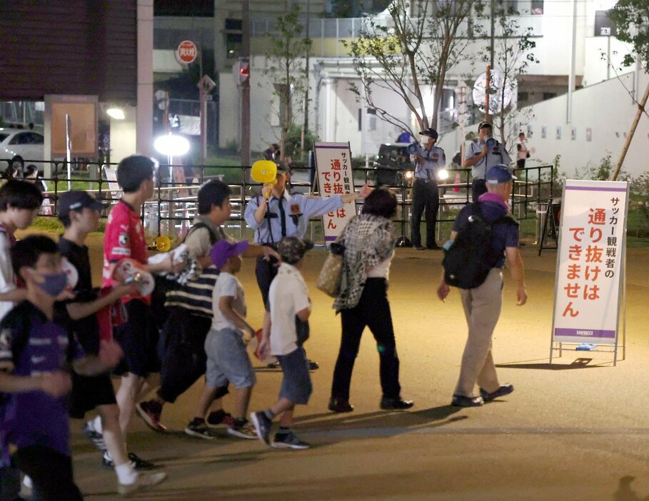 観客が基町アパート方面（奥）に通り抜けないよう、周知する看板が立つ試合日のスタジアム周辺（11日）