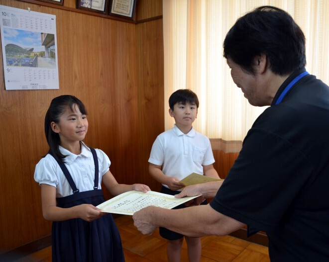 浜田さん（右）から賞状を受け取る山本さん（左）と古谷さん