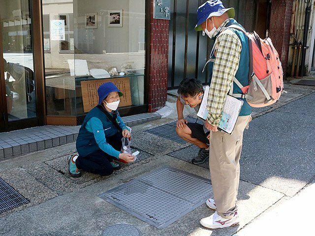 地下を流れる温泉について説明するナチュラリスト（左）。幅広い知識で参加者を楽しませる