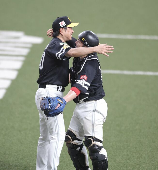 優勝し甲斐拓也と抱き合う小久保裕紀監督