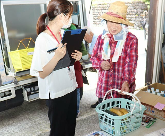 お年寄りに取材する山本記者（左）＝８月６日、朝日町笹川地区