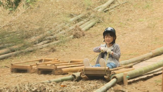 竹のすべり台で遊ぶ子ども＝29日午前11時ごろ、越前市の村国山