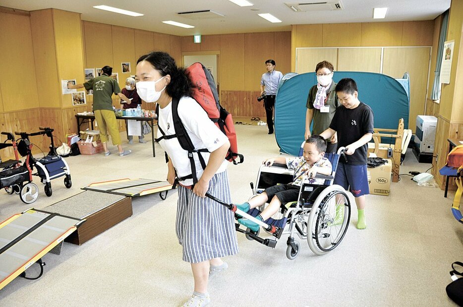 人力車のように車椅子を引ける補助器具を試す参加者